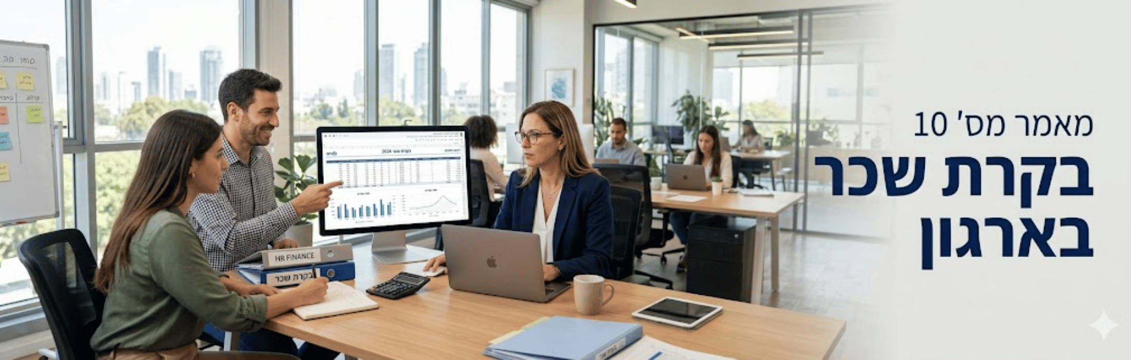 Three coworkers discuss data at a bright office desk, looking at a large monitor with charts and spreadsheets nearby.